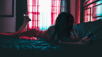 Woman playing on her phone in bed