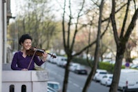 violinist Jessy Koch performs on her balcony as each day to support health workers in Mulhouse, eastern France